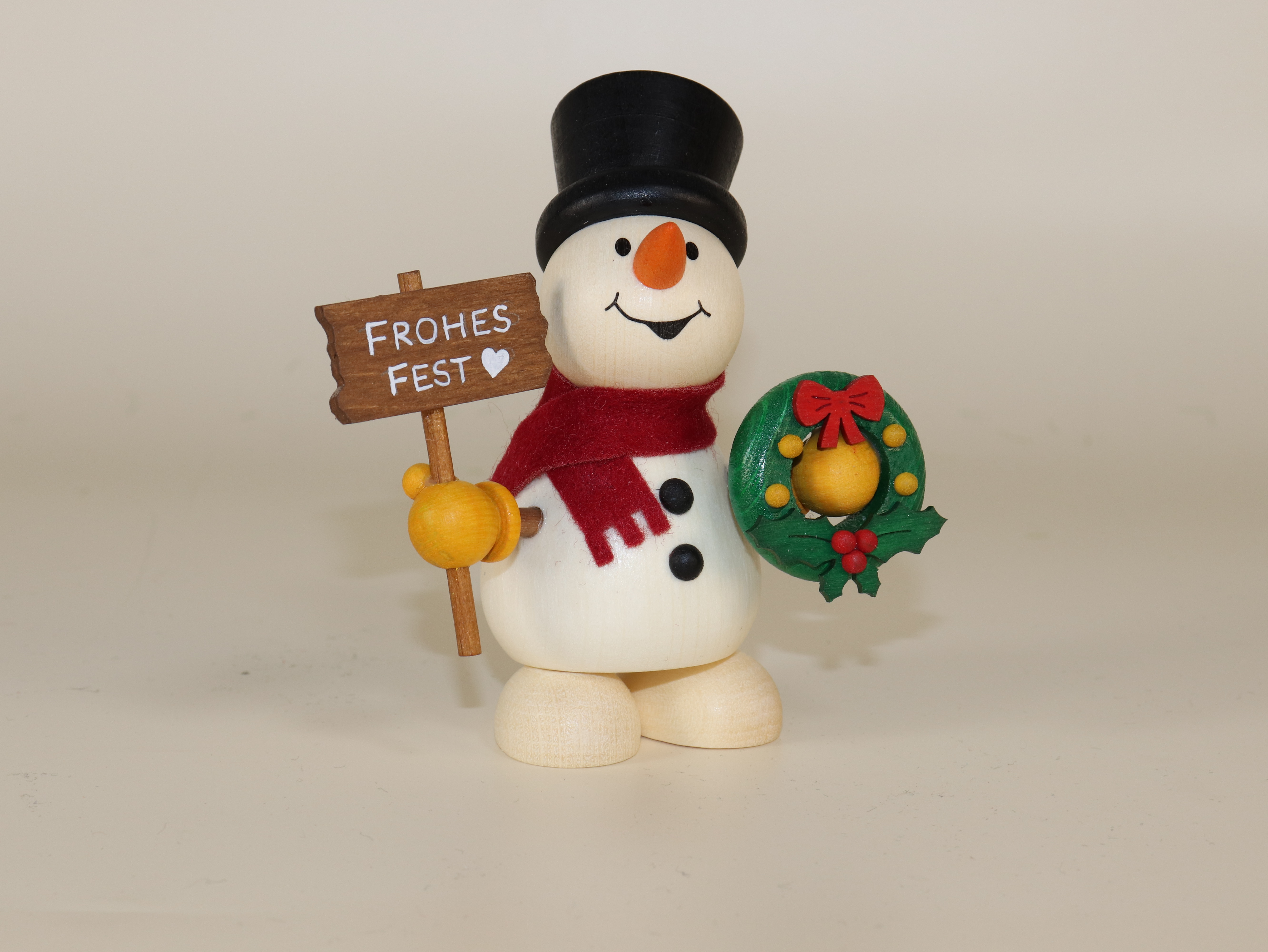 Holzfigur Schneemann mit Schild "Frohes Fest" und Weihnachtskranz in der Hand 9,5 cm groß zum Hinstellen